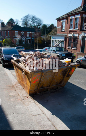 Skip Building Rubble A building skip full of rubble in a street in Newquay Town centre in ...
