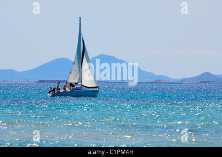 A small yacht sailing on the Mediterranean Sea near Dehesa de Campoamor on the Costa Blanca Coast Alicante province, Spain. Stock Photo