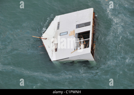 Aerial photo taken March 14 2011 of a house floating at sea near Sendai, Japan, in the aftermath of the earthquake + tsunami. Stock Photo