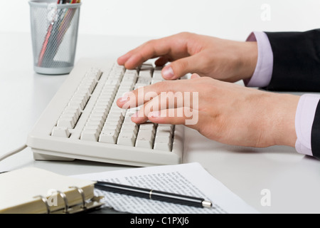 Close-up of male hands pressing keys of computer board on workplace Stock Photo