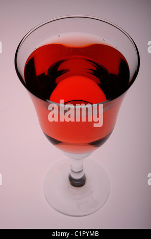 A cool glass of rose wine against a contoured backdrop lit from below. Stock Photo