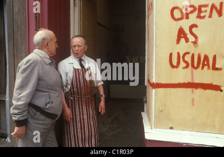 Toxteth Riot 1980s UK. A butcher in his butchers apron stands outside ...