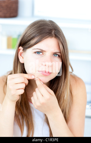 Young woman standing in front of a mirror in a bathroom Stock Photo