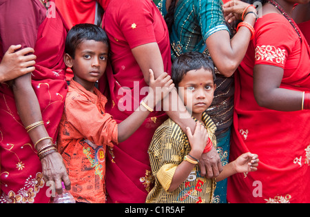 Boys with mothers in line of Hindu pilgrims at entrance to Sri Meenakshi Sundareswarar Temple in Madurai Stock Photo