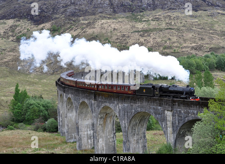The Hogwarts Express featured in Harry Potter movie running on the Glenfinnan viaduct, Scottish Higlands Stock Photo