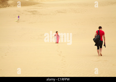 People climbing giant Te Paki Sand Dunes to go dune boarding, Far North, Northland, North Island, New Zealand Stock Photo