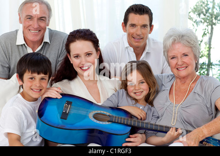 Portrait of family holding a guitar in living-room Stock Photo