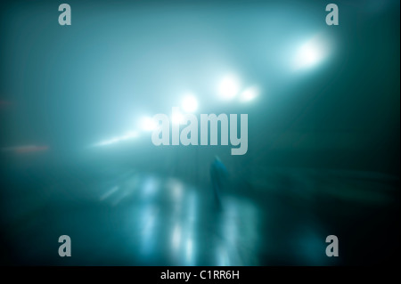 Mysterious figure walking on a wet foggy night. Stock Photo