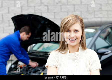 Man repairing car of smiling woman Stock Photo