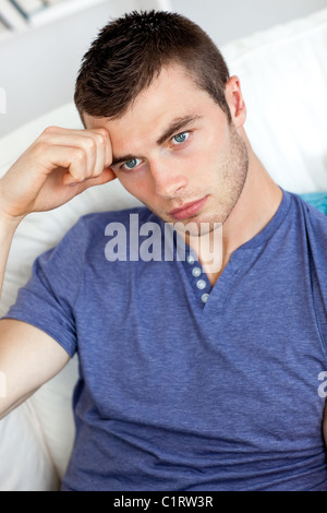 Bored young man sitting on the sofa Stock Photo
