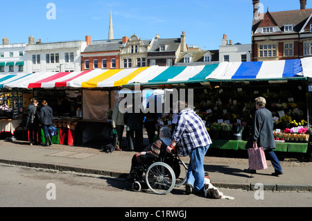Stalls on the Market, and Man pushing Senior Woman in Wheelchair, Cambridge, England, UK Stock Photo