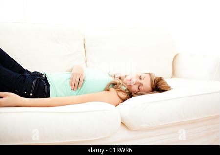 Caucasian blond woman lying on a sofa relaxing Stock Photo