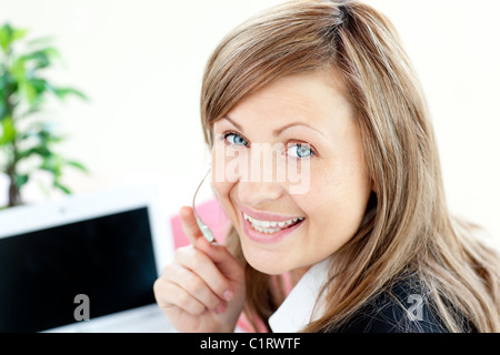 Radiant young businesswoman wearing headphones Stock Photo