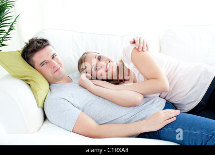 Enamored young couple lyingo together on the sofa Stock Photo