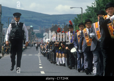 Belfast The Troubles. 1980s.Orange Day Parade through outskirts of Belfast RUC police officers give some protection. 1980s Outskirts of Belfast HOMER SYKES Stock Photo