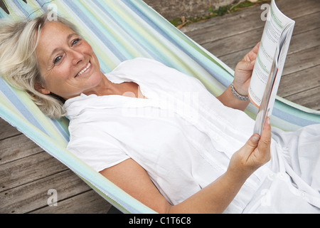 Mature woman relaxing in hammock, portrait