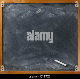 straight on view of a used blackboard and chalk ready for copy to be written Stock Photo