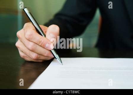 Businessman signing paperwork, cropped Stock Photo