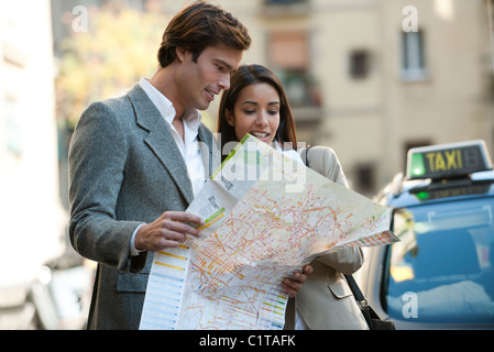 Couple consulting map outdoors