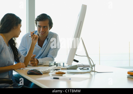 Couple sitting together at computer desk Stock Photo