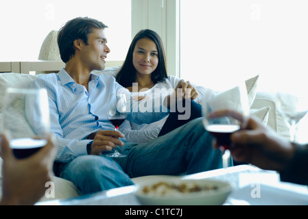 Couple enjoying red wine with friends Stock Photo