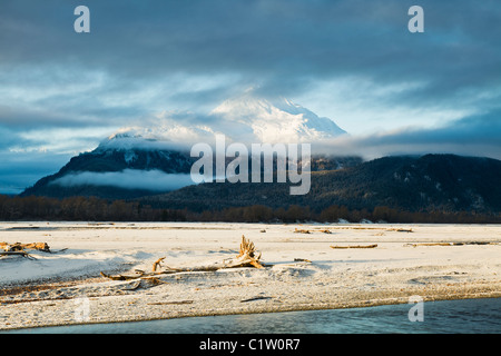 Clouds and mist enhance the sunrise on the Chilkat Mountains and Chilkat River bed outside Haines, Alaska. Stock Photo