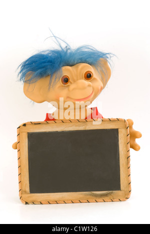 Troll boy with blue hair holding a blank message slate chalkboard. Stock Photo
