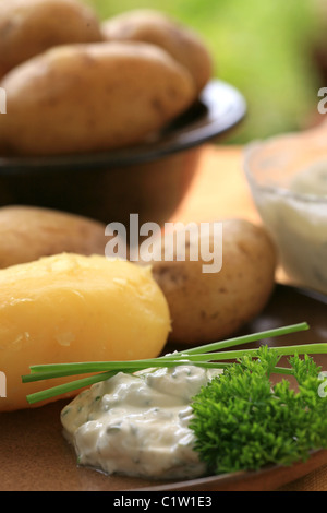 Baked potato with cream cheese and herbs Stock Photo