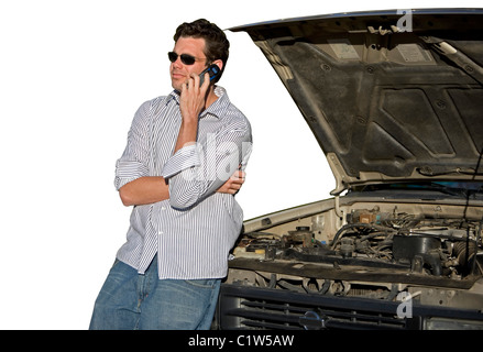 A man calls for help on a cell phone from a stranded car. Stock Photo