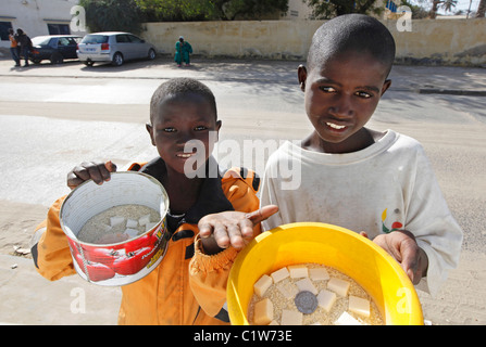 Young Talibé (students from a koranic school) beg on the streets of Saint Louis, Senegal Stock Photo