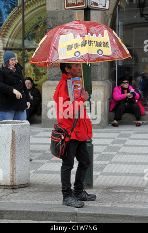 Hop on Hop off tour bus guide advertising tourist tours on an umbrella in Prague, Czech Republic
