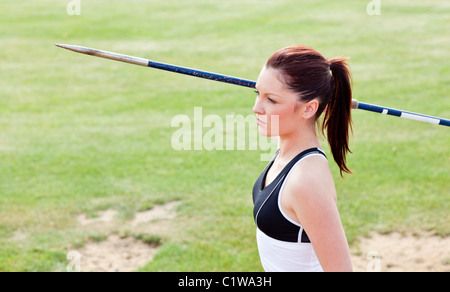 Concentrated female athlete ready to throw javelin Stock Photo