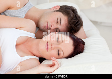 Enamored young couple sleeping in bed together Stock Photo