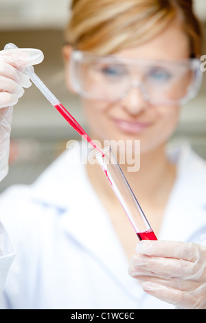 Close-up of a female scientist putting liquid in a test tube with a pipette Stock Photo