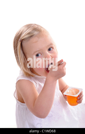 little girl eating yogurt, mouth wide open. isolated on white Stock Photo