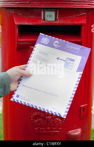 person posting completed census form in post box uk Stock Photo