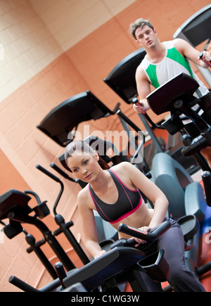 Serious young couple doing exercises using equipments in a sport centre Stock Photo