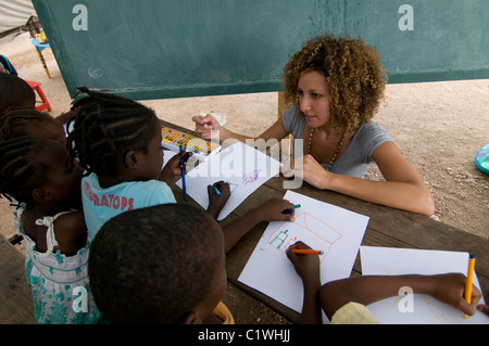 Noa Yaakov Israeli volunteer of Natan International Humanitarian Aid drawing with young orphans during art therapy session in a makeshift camp for survivors of a 7.0 magnitude earthquake which struck Haiti on 12 January 2010 in  the outskirts of Port-au-Prince Stock Photo