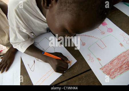 Orphans drawing in a camp for survivors of a 7.0 magnitude earthquake which struck Haiti on 12 January 2010 in  the outskirts of Port-au-Prince Stock Photo