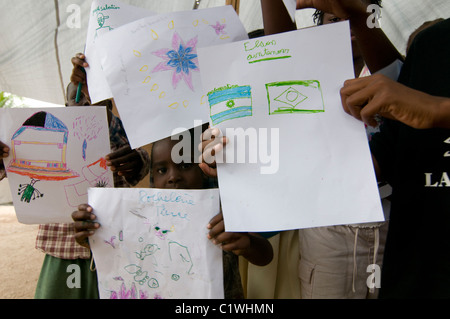 Orphans showing their drawing in a camp for survivors of a 7.0 magnitude earthquake which struck Haiti on 12 January 2010 in  the outskirts of Port-au-Prince Stock Photo