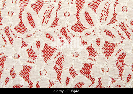 White lace with pattern in the manner of colour on red background Stock Photo