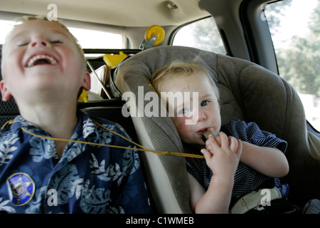 2 Brothers playing off in the back of the mini-van during a family vacation. Stock Photo