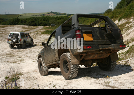 Two 4x4 off road vehicles driving in a chalk pit. Stock Photo