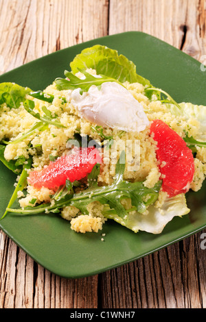 Couscous with red orange and rocket, poached egg on top Stock Photo