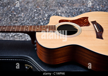 Acoustic guitar sitting on it's closed case. Stock Photo