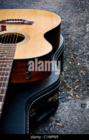 Acoustic guitar sitting on it's closed case. Stock Photo
