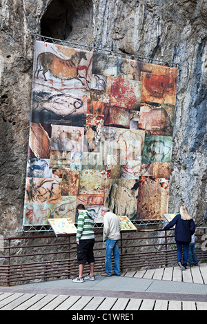 People reading information signs about prehistoric cave art Grotte de Niaux department Ariege France Stock Photo