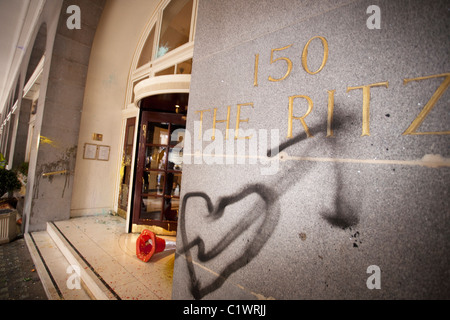 Main entrance to the Ritz Hotel daubed with graffiti by Anarchist protesters during Anti-cuts demonstration in London. Stock Photo