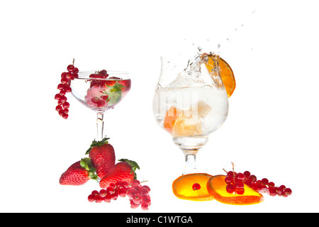 fresh fruits dropped in glass of sparkling water Stock Photo