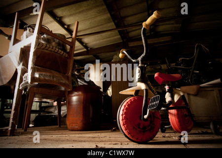 old  abandoned toy trike in shed Stock Photo